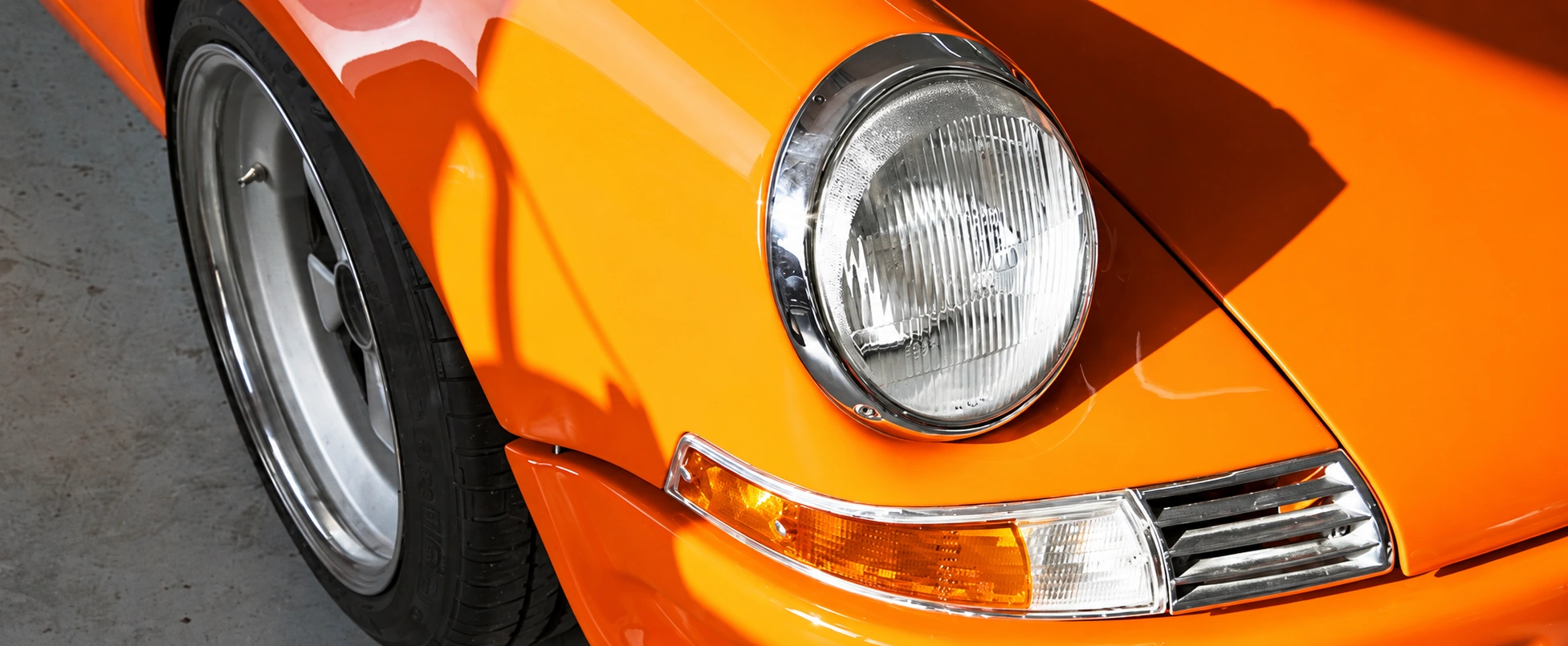 Scheinwerferdetail eines orangefarbenen klassischen Porsche