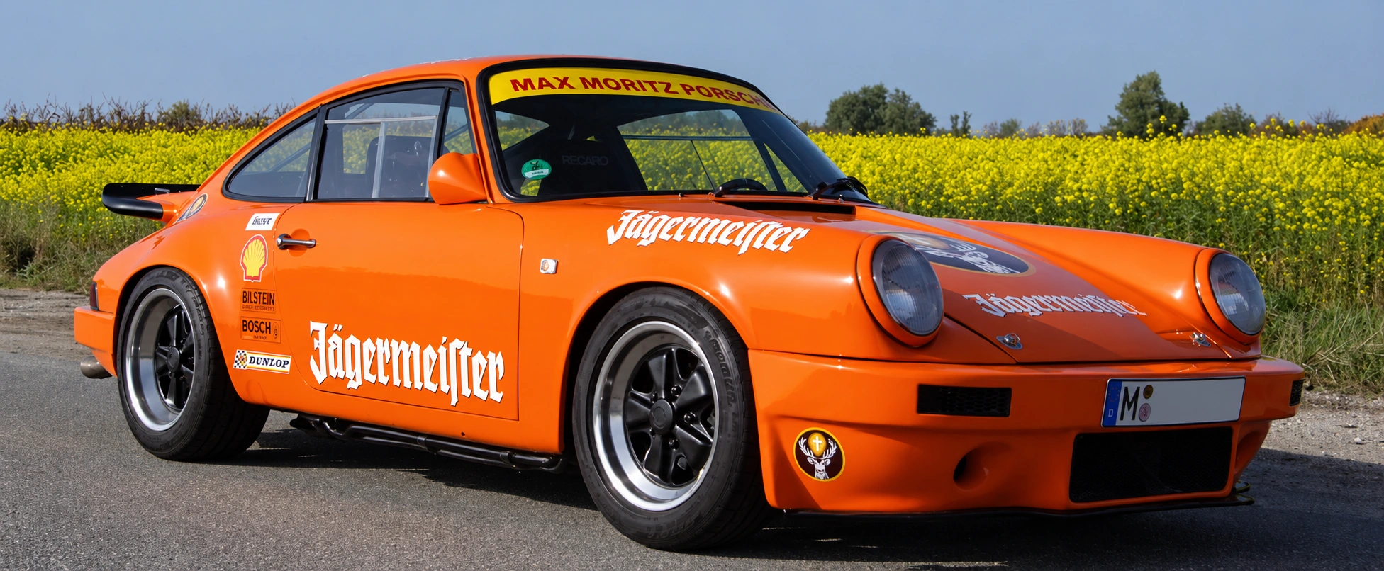 Orangefarbener klassischer Porsche mit Rennsportbeklebung