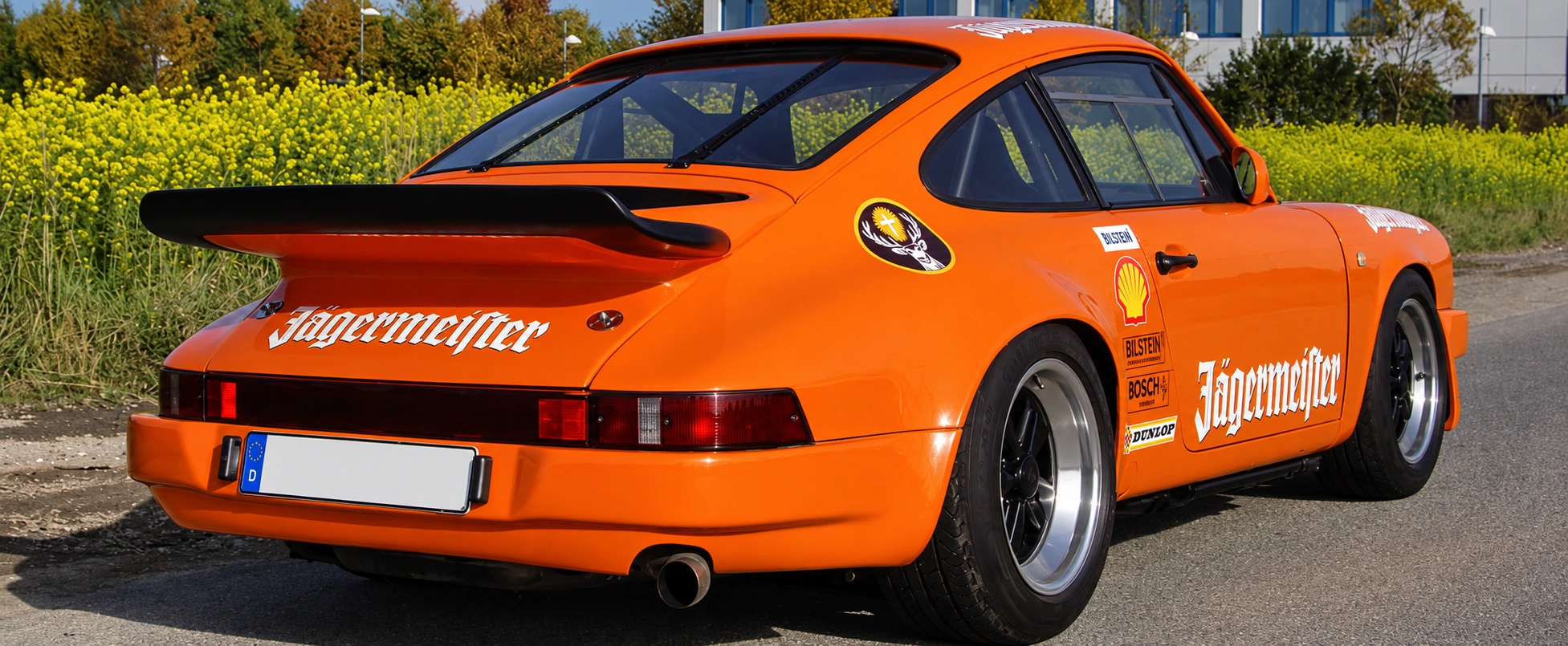 Orangefarbener klassischer Porsche von hinten