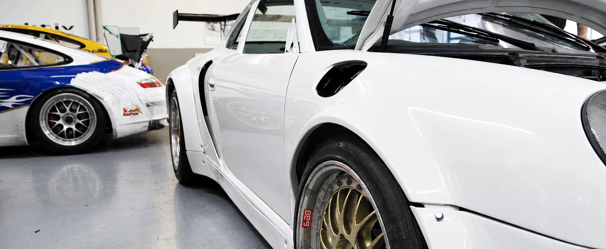 Detail einer Porsche-Karosserie im Werkstattumfeld
